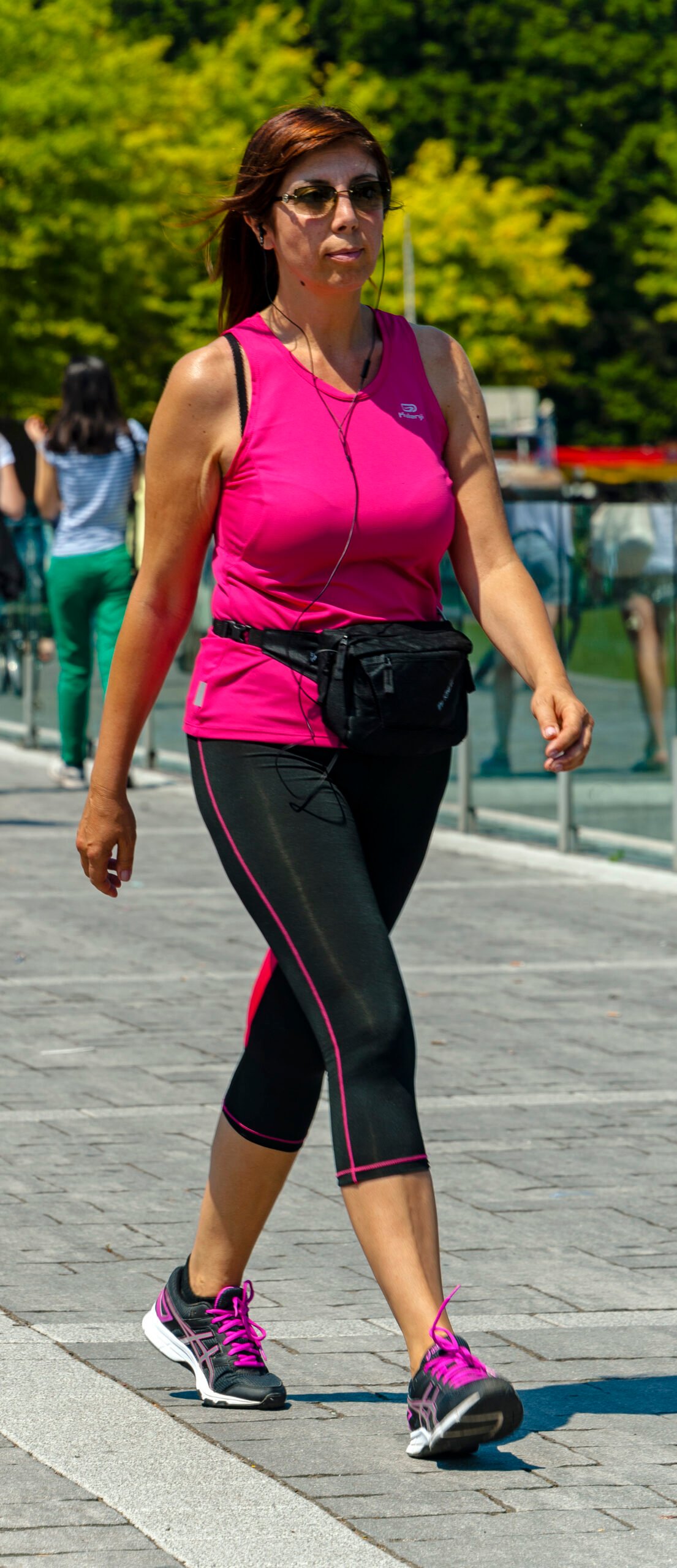 Woman walking in exercise clothing by a lake